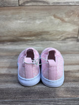 Rear view of pink Cat and Jack toddler glitter slip-on sneakers with elastic bungee tie and white rubber soles on wood