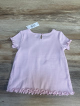 Back view of Baby Gap ribbed lettuce-trim baby shirt showing keyhole button, ruffled sleeves, and lettuce hem on wood background