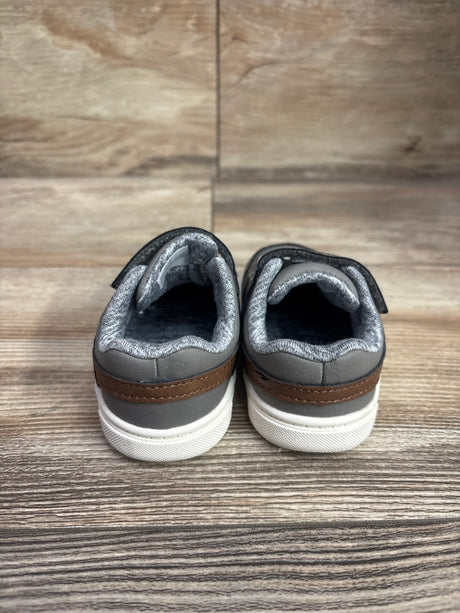 Rear view of Just One You First Walker Sneakers Grey sz 4c showing brown heel stripes and white soles on a wood floor