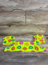Bright yellow kids' swimsuit set with colorful smiley face flowers on wooden background
