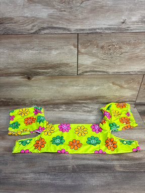 Bright yellow kids' swimsuit set with colorful smiley face flowers on wooden background