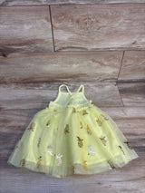 Flat lay of Cat & Jack yellow tulle tank dress with gold pineapple foil print and layered tulle skirt on wood background
