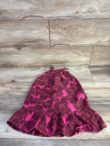 Flat lay of girls' RubiMoon floral smocked dress showing smocked top with tie straps and ruffled hem on wood floor