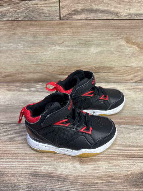 Angled view of AND1 black and red kids basketball sneakers with lace up, padded collar and speckled midsole on wood floor