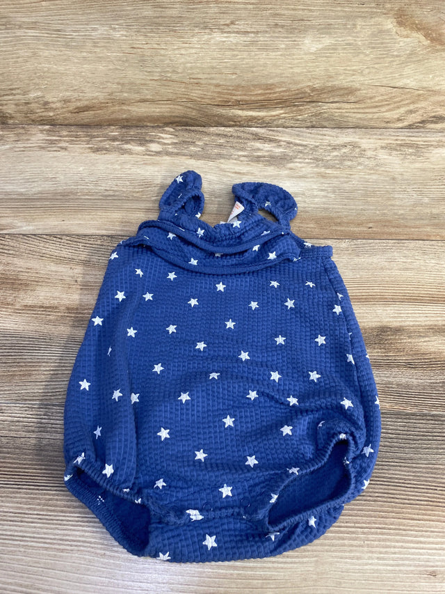 Flat lay of blue Cat & Jack bubble romper showcasing white star print, ruffled shoulder straps and snap crotch on wood background
