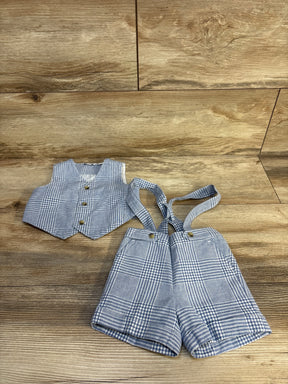 Blue and white gingham baby boy outfit with vest and suspenders shorts on wood floor