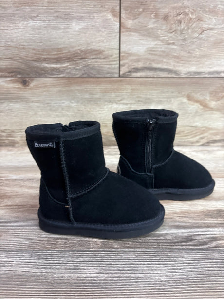 Front three-quarter view of BearPaw Eliza boots showcasing side zippers and black uppers on a wood floor