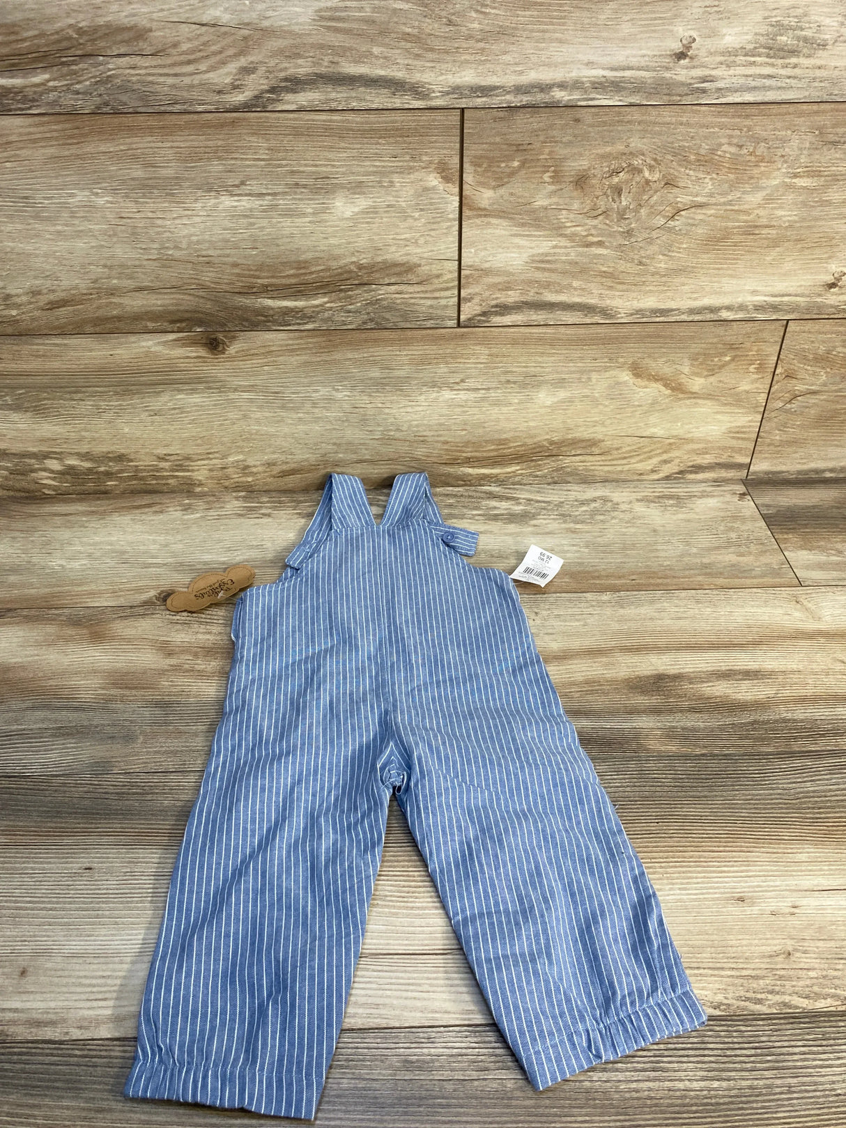 Blue and white striped toddler overalls on wood background, children's resale clothing.