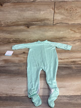 Back view of mint green Disney Dumbo footed sleeper showing long sleeves and attached size tag on wood floor