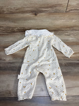 White baby romper with yellow polka dot pattern and ruffle collar on wood floor