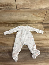 Flat lay of Simple Joys white preemie footed sleeper showcasing small multicolor rainbow print on wood floor background