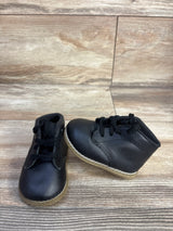 Front three-quarter view of Teeny Toes Oxford shoes, pair showing black leather upper, tan sole and laces on wooden floor