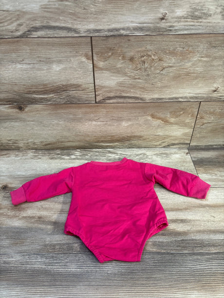 Back view of newborn hot pink long-sleeve bodysuit showcasing ribbed cuffs and elastic leg openings with wood plank background
