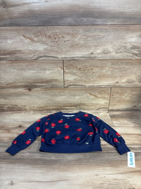 Navy blue kids sweater with red apple print, Carter's brand, laid on wood floor