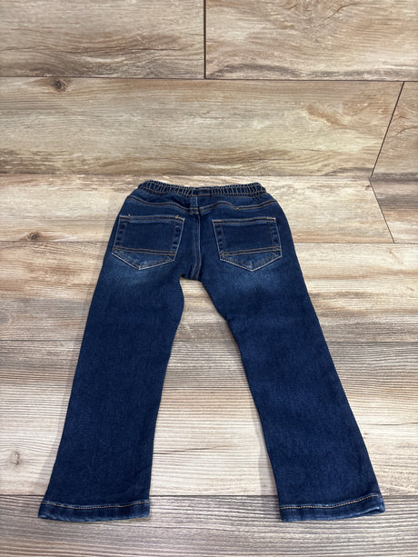 Back view of blue Cat & Jack drawstring skinny jeans for toddlers size 2T on a wood background.