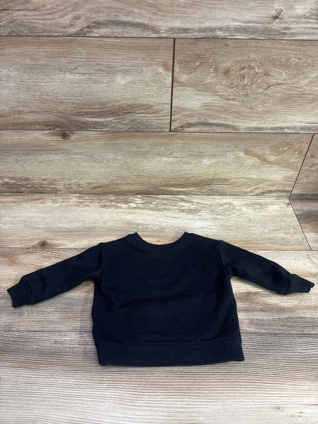 Front view of Jumping Beans Disney Stitch black pullover sweatshirt with ribbed trim laid on a wood-look floor