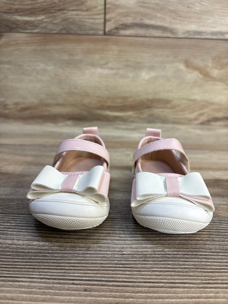 Pink and white baby girl shoes with bows on wooden floor, kids footwear