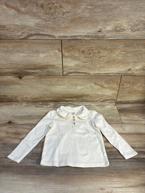 Flat lay of cream Gymboree long-sleeve Peter Pan collar top with ruffle collar and three buttons on wood floor, size 3T