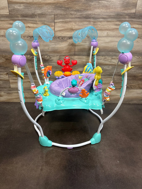 Front view of Bright Starts The Little Mermaid Sea of Activities Jumper showcasing ocean-themed toys and padded seat