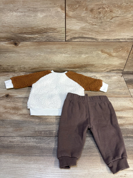Brown and white sherpa toddler sweatshirt with matching brown jogger pants on wood floor