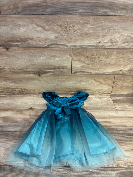Flat lay of teal velvet and tulle 4T dress showing puff sleeves, satin waist bow, and glittery layered skirt on wood floor