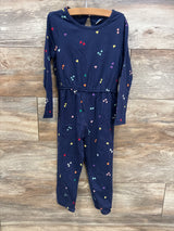 Navy blue toddler jumpsuit with colorful heart patterns hanging on wooden background