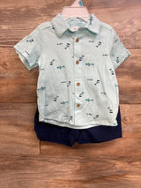Front view of Carter's light-blue button-up shirt with fish print and wooden buttons with navy shorts on wood floor