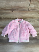 Pink fuzzy baby bomber jacket with white stripes, size 24M, laid on wood floor