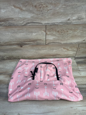 Pink baby car seat cover with white and black arrow pattern on wood background
