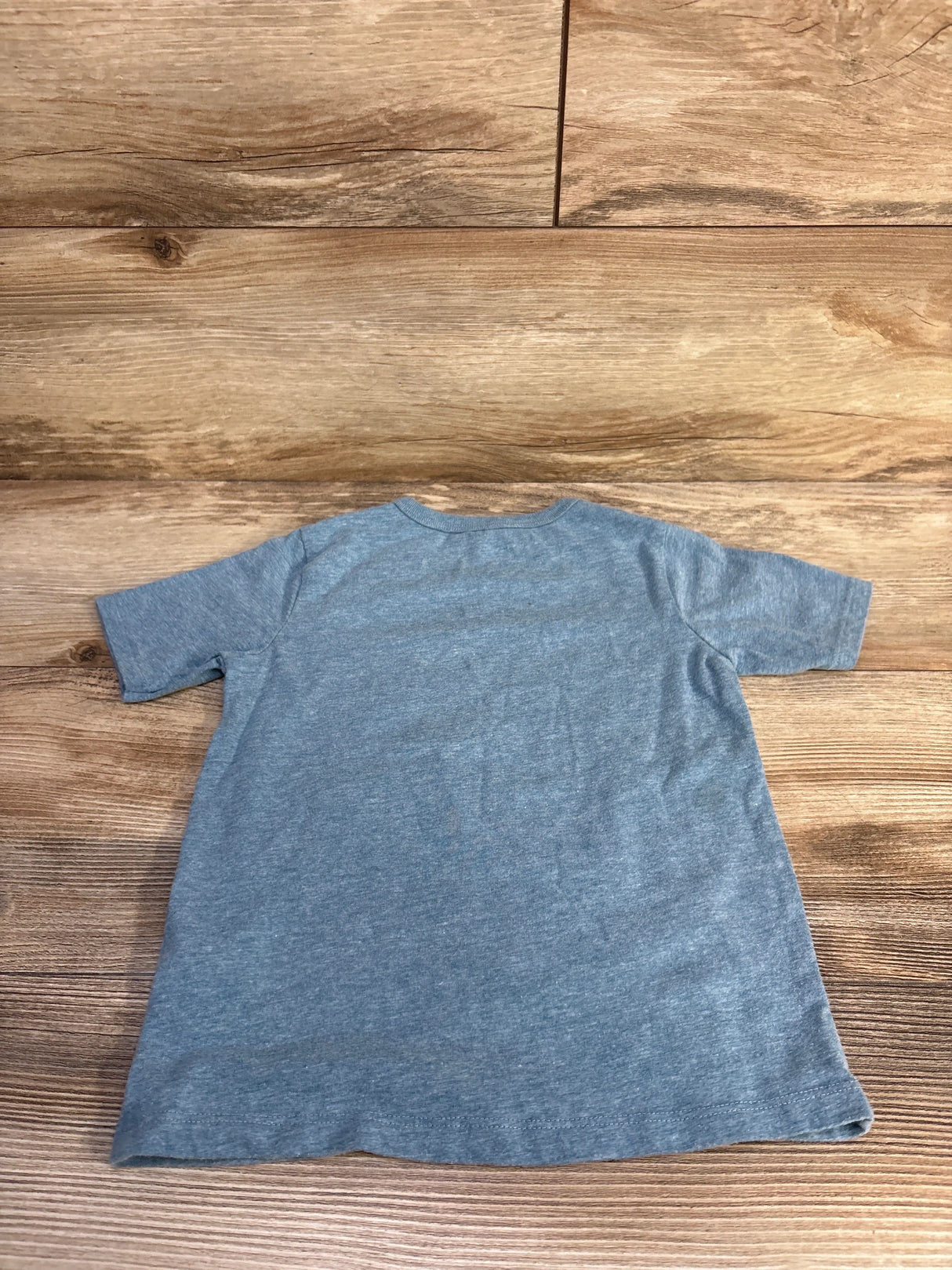 Back view of Children's Place blue toddler T-shirt (4T) showing short sleeves and crew neck on wood background