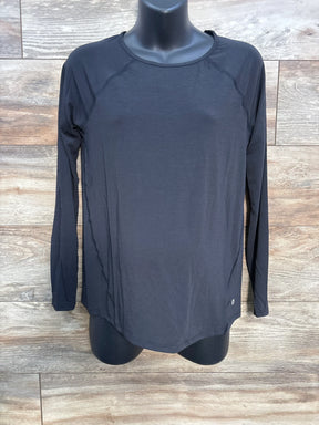 Black long sleeve athletic shirt on mannequin against wood background