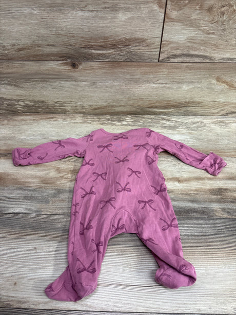Top view of Just One You pink sleeper in size 3 months showcasing long sleeves, footed design, and bow print on a wood floor