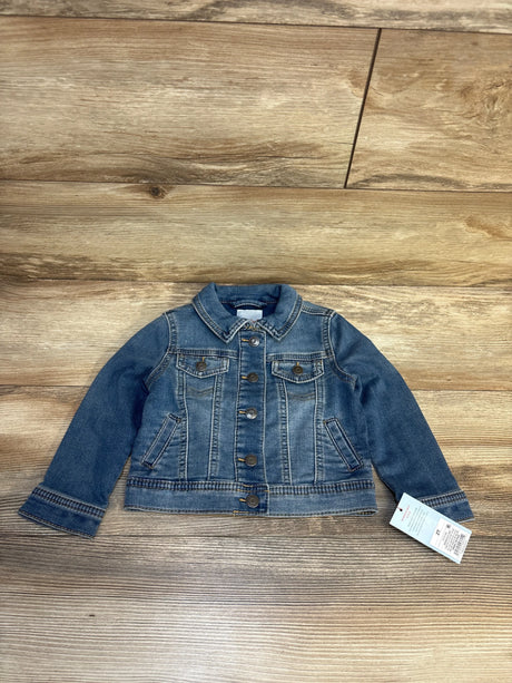 Kids blue denim jacket with button closure and front pockets on wood background