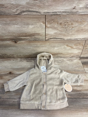 Beige plush baby hoodie jacket with buttons, long sleeves, and hood on wood background