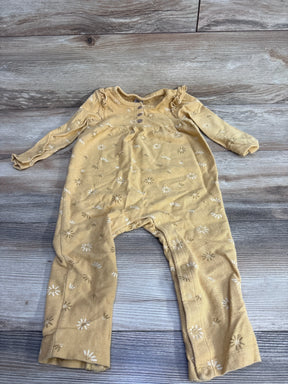 Yellow long-sleeve baby romper with white floral print laid flat on wood floor