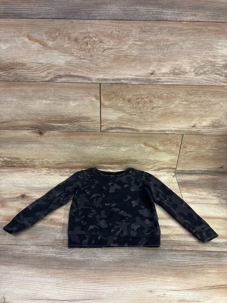 Front view of Ideology pullover sweatshirt showcasing black camouflage pattern with wood-look background