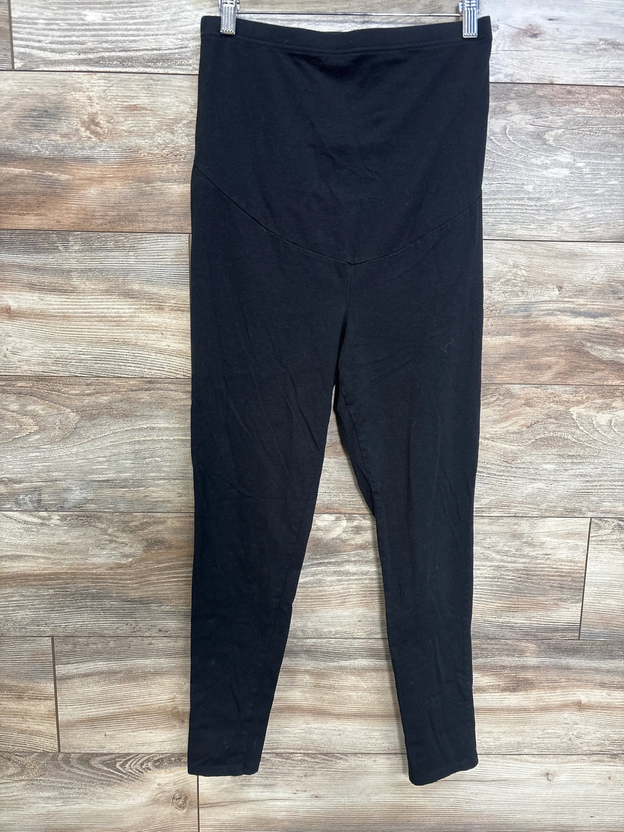 Front view of black Time and Tru maternity leggings showing high-rise maternity panel and full-length legs on wooden floor background
