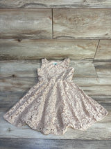 Flat lay of Lily Bleu beige lace girls dress size 4T showcasing scalloped hem and floral lace on light wood background