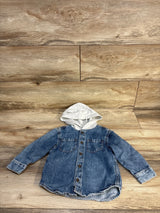 Baby denim hoodie shirt with gray hood, button front, and pockets on wood floor