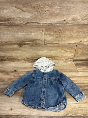 Baby denim hoodie shirt with gray hood, button front, and pockets on wood floor