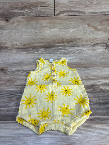 Flat lay of Old Navy sleeveless henley baby romper showing yellow smiling sun print and button placket on wood background