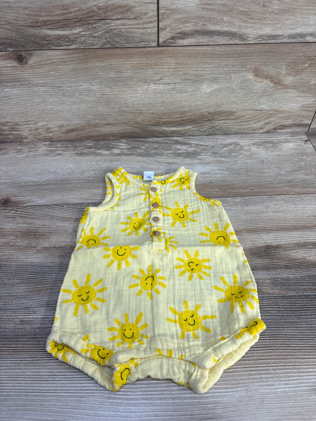 Flat lay of Old Navy sleeveless henley baby romper showing yellow smiling sun print and button placket on wood background