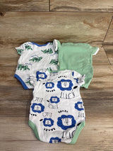 Three baby bodysuits on wood floor, two with animal prints, one solid green, short sleeve.