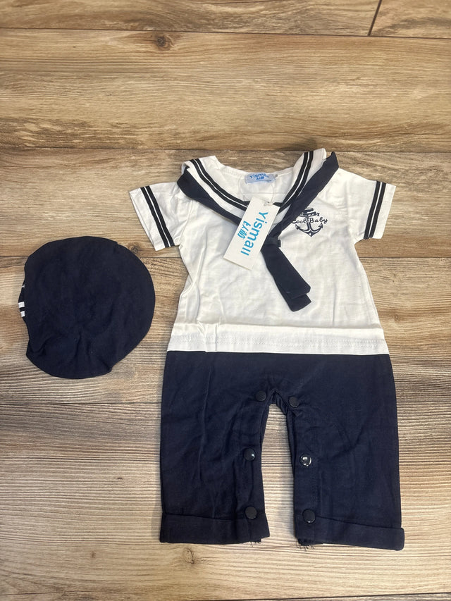 Infant navy and white sailor romper with matching hat on wood surface
