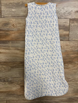 Flat lay of Angel Dear 1.0 TOG sleep bag showing sleeveless white knit with small blue floral-and-bow pattern on wood floor