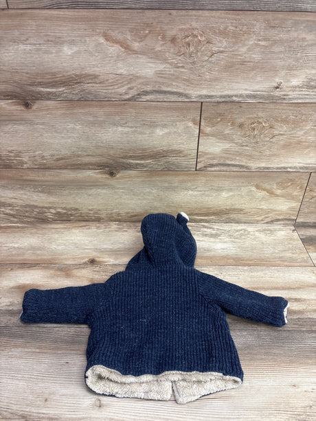 Navy blue Baby Gap knit bear cardigan with hood and cream lining on wood background