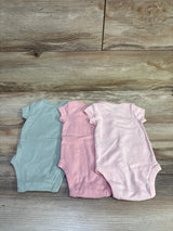Top-down view of Carter’s three-pack bodysuits in blue, pink, and pale pink with short sleeves on a wood surface