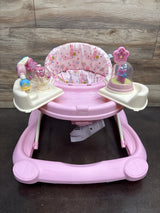 Front view of Disney Music & Lights Baby Walker in Happily Ever After showcasing pink padded floral seat and activity toys with a wood backdrop