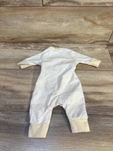 Cream and white striped baby onesie with long sleeves, laid flat on wood floor