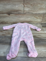 Front flat lay of plush pink blanket sleeper showcasing raised heart pattern and built-in footies on wood plank background